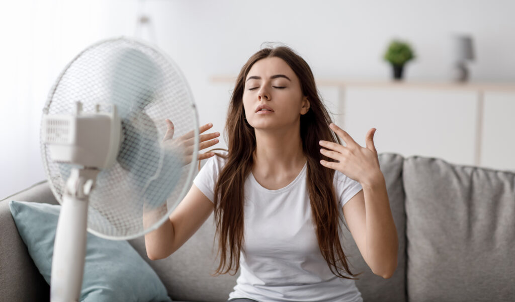 Young woman sitting in front of a fan